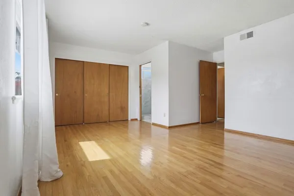 a view of an empty room with wooden floor