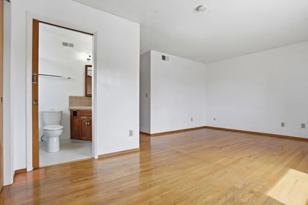 a view of an empty room and wooden floor