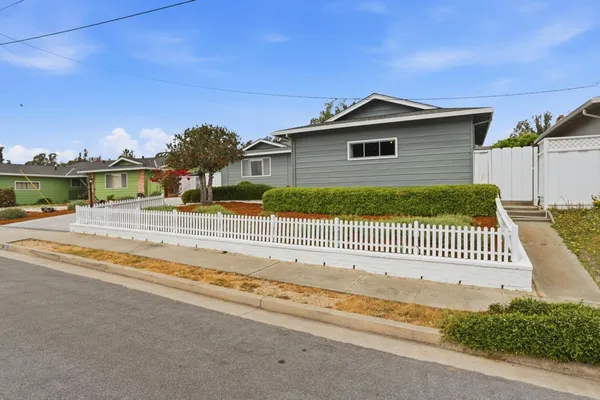 a view of a house with a yard and fence