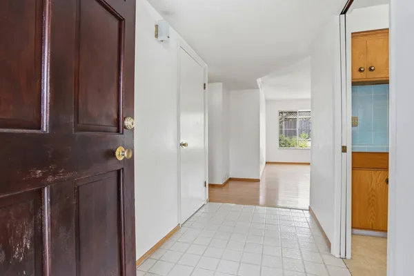 a view of a hallway with wooden floor and a cabinet