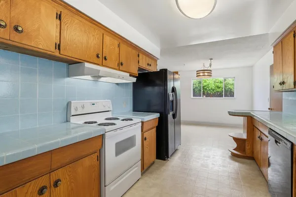a kitchen with stainless steel appliances granite countertop a stove a refrigerator and a cabinets