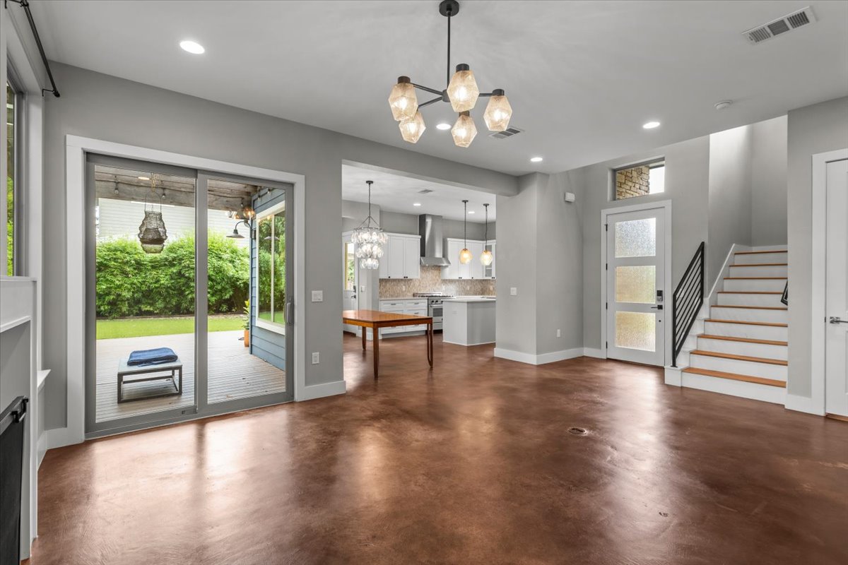 913 Stobaugh Street, Unit B Austin, TX 78757 - Photo 12 of 40 A spacious living area with warm, gleaming floors connects seamlessly to a modern kitchen and an outdoor deck.