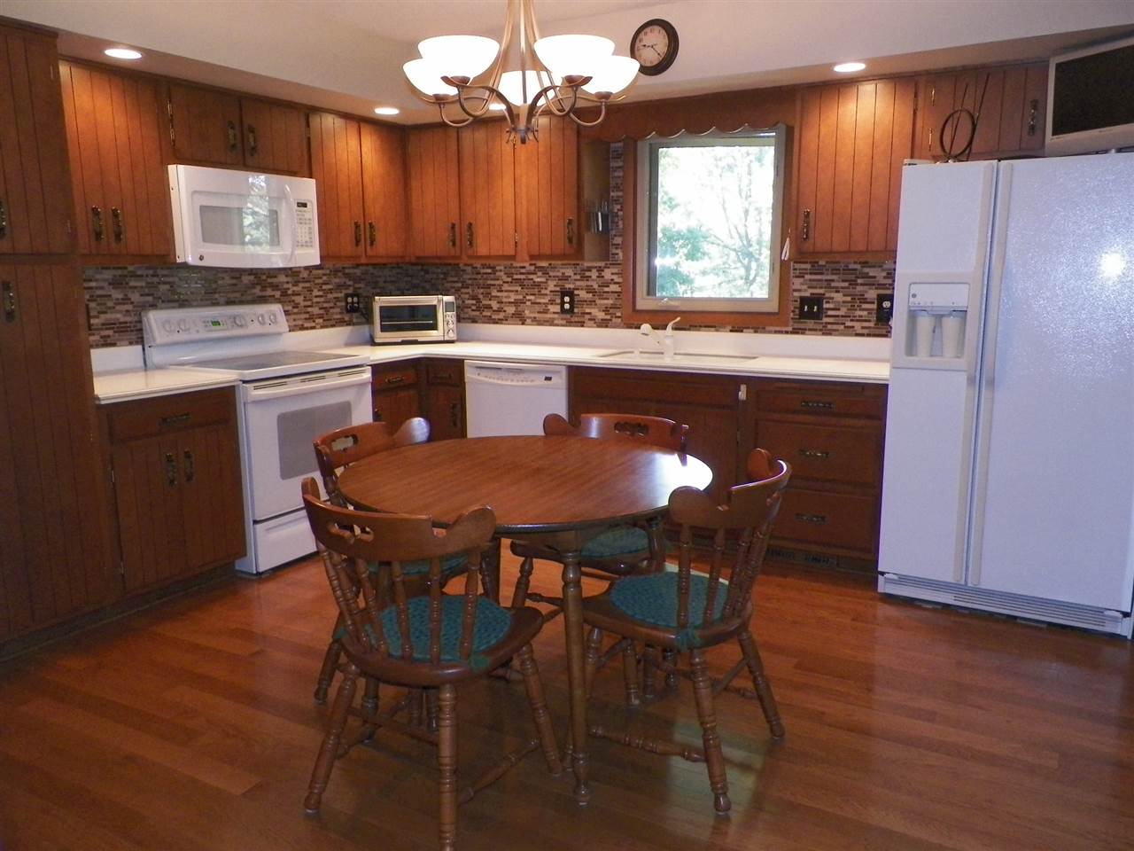 2995 East Water Road Byron, IL 61010 - Photo 3 of 25 a kitchen with a dining table chairs and refrigerator