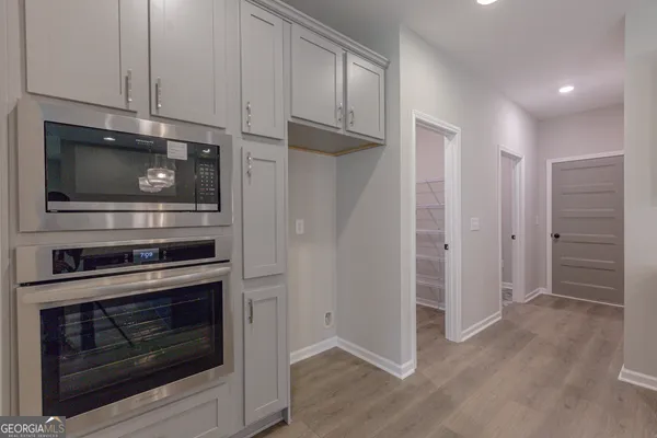 a kitchen with white cabinets and stainless steel appliances