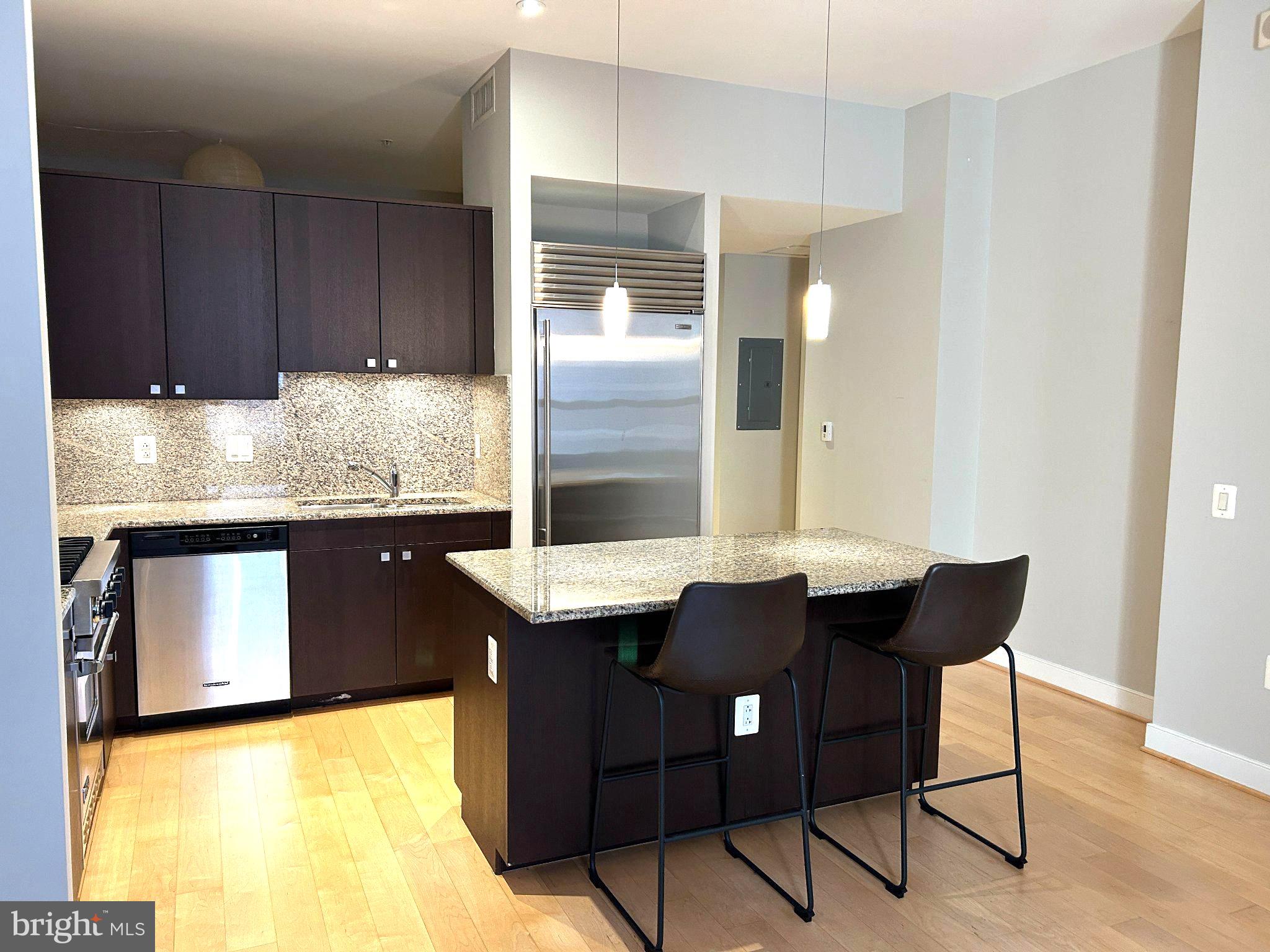 2425 L Street Northwest, Unit 421 Washington, DC 20037 - Photo 7 of 18 Sleek modern kitchen with island seating.