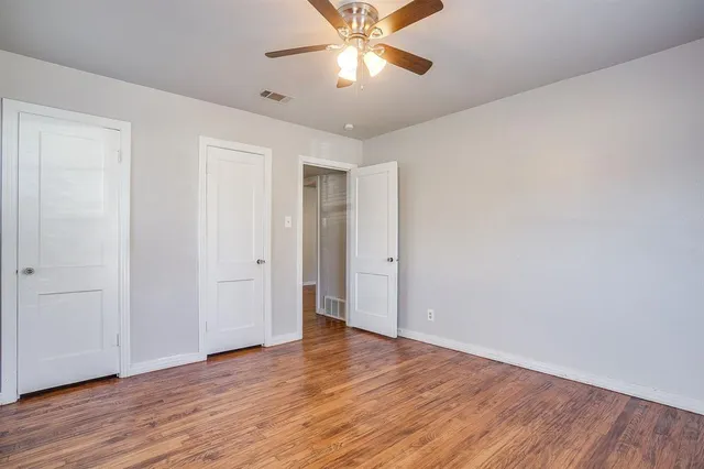 a view of a room with wooden floor and a ceiling fan