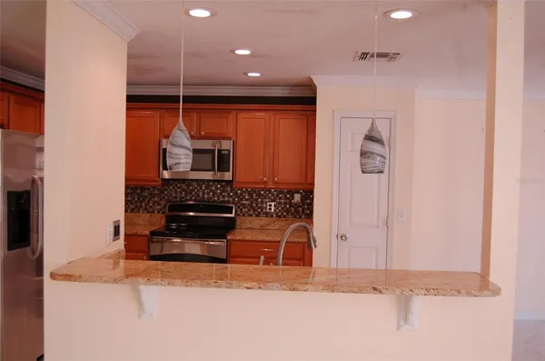 a kitchen with stainless steel appliances granite countertop a refrigerator a sink and a stove