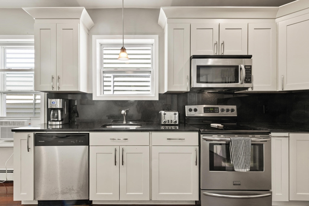 573 Bennington Street, Unit 2 Boston, MA 02128 - Photo 13 of 22 a kitchen with granite countertop white cabinets and appliances