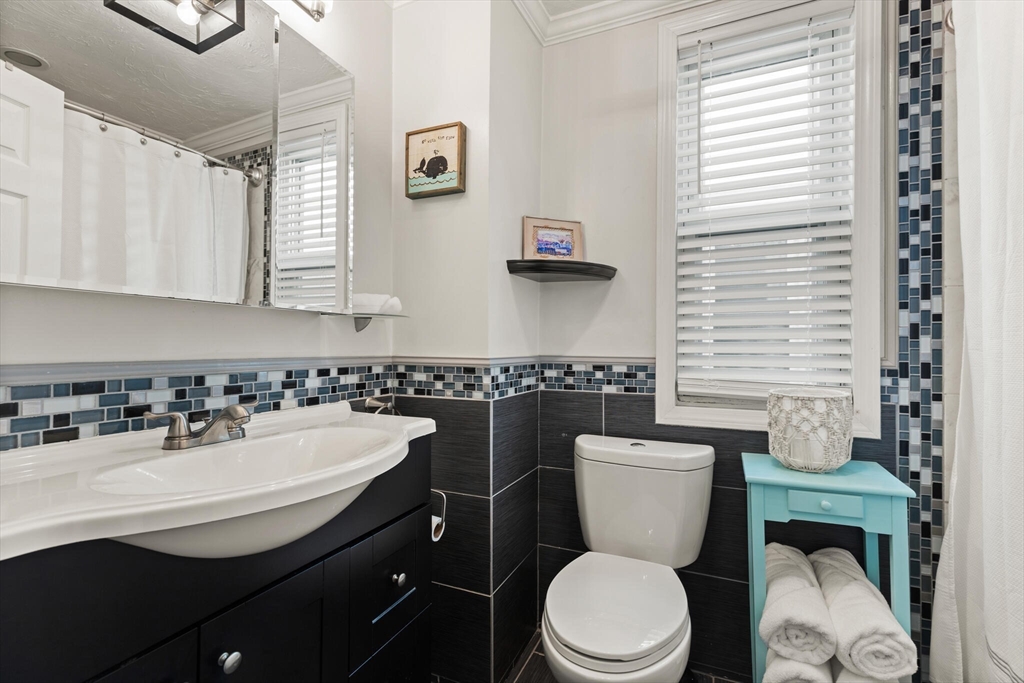 573 Bennington Street, Unit 2 Boston, MA 02128 - Photo 19 of 22 a bathroom with a toilet a sink and a mirror