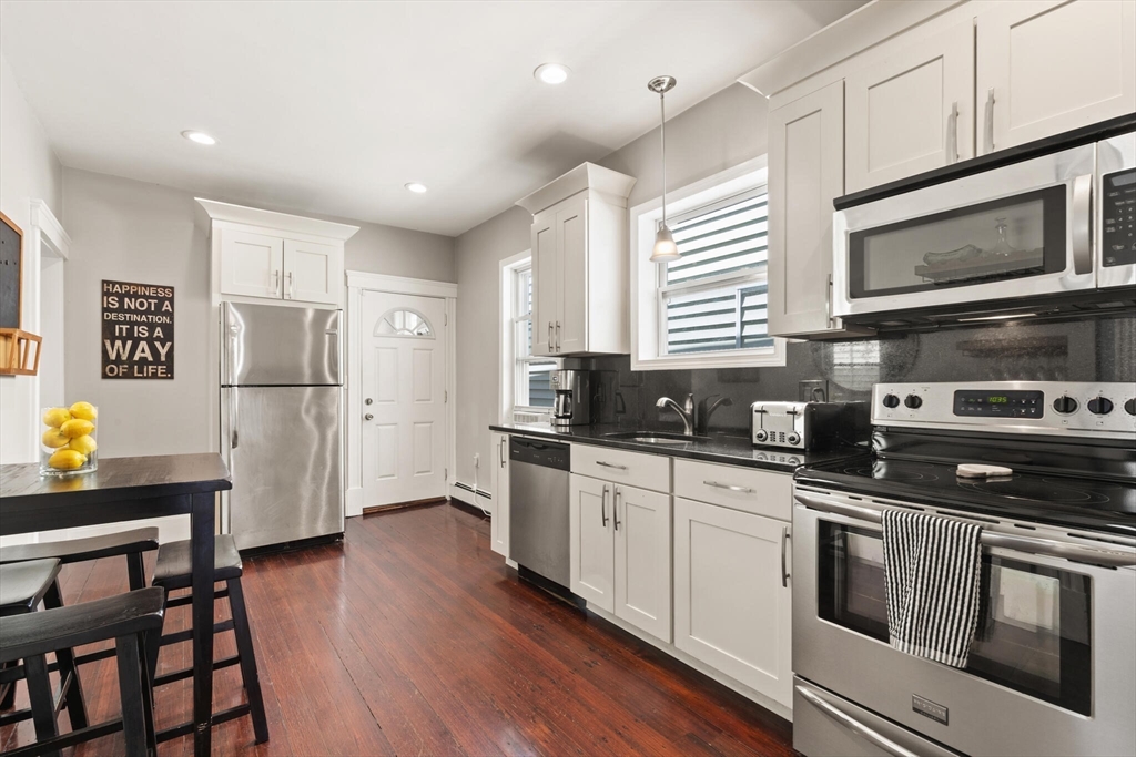 573 Bennington Street, Unit 2 Boston, MA 02128 - Photo 10 of 22 a kitchen with stainless steel appliances granite countertop a refrigerator microwave and stove