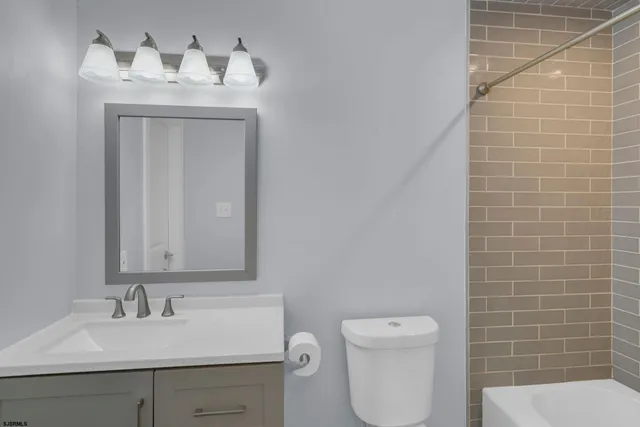 a bathroom with a toilet a sink and mirror