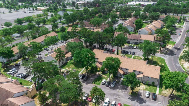 an aerial view of residential houses with outdoor space and trees all around
