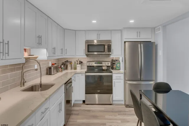 a kitchen with stainless steel appliances granite countertop a refrigerator stove and sink