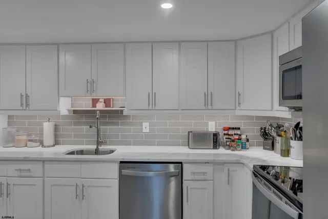 a kitchen with stainless steel appliances granite countertop a sink a stove a microwave and cabinets