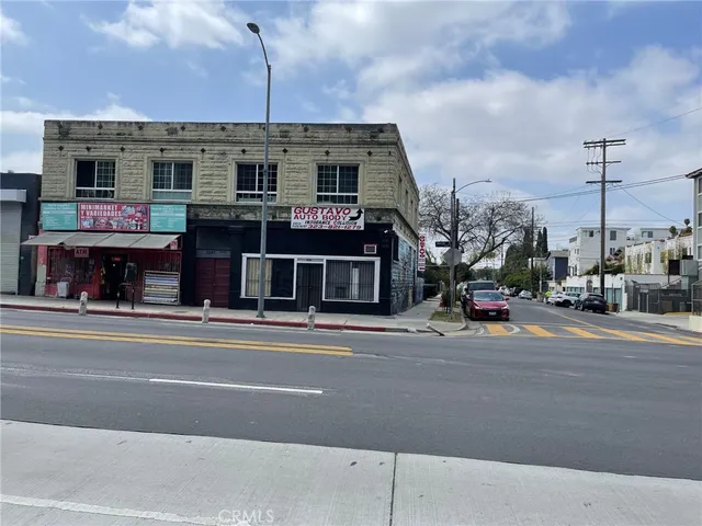 a view of a building and a cars park on the road