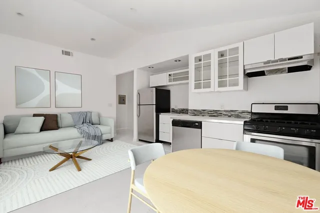 a kitchen with granite countertop a stove a sink and a refrigerator