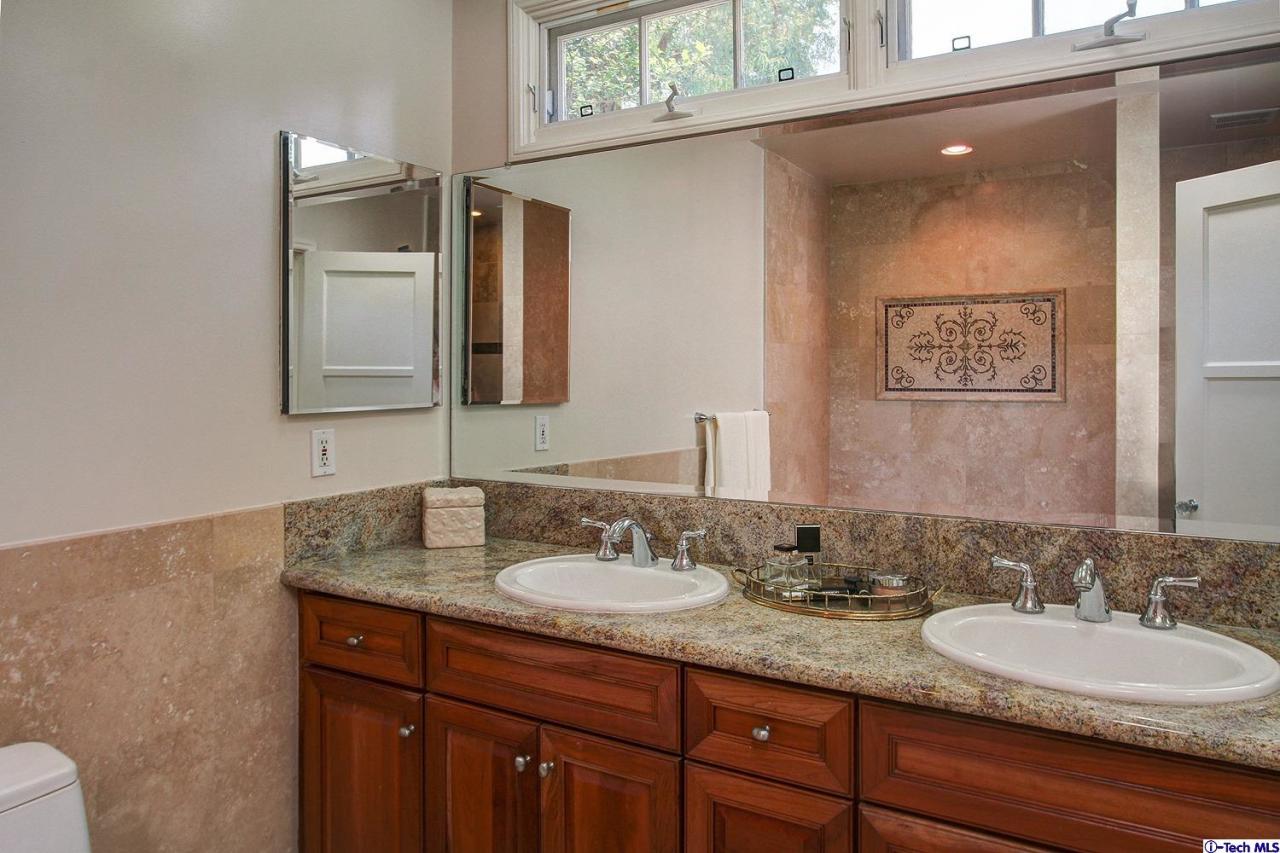 931 Roxbury Road San Marino, CA 91108 - Photo 22 of 37 a bathroom with a granite countertop sink and a mirror