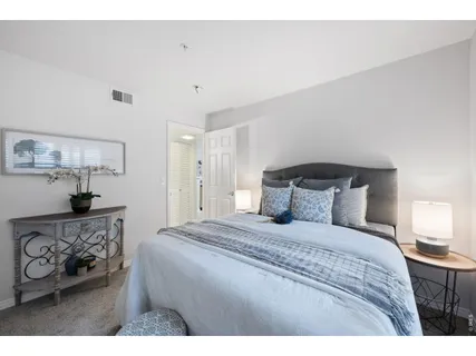 a bedroom with a bed a dresser and a window