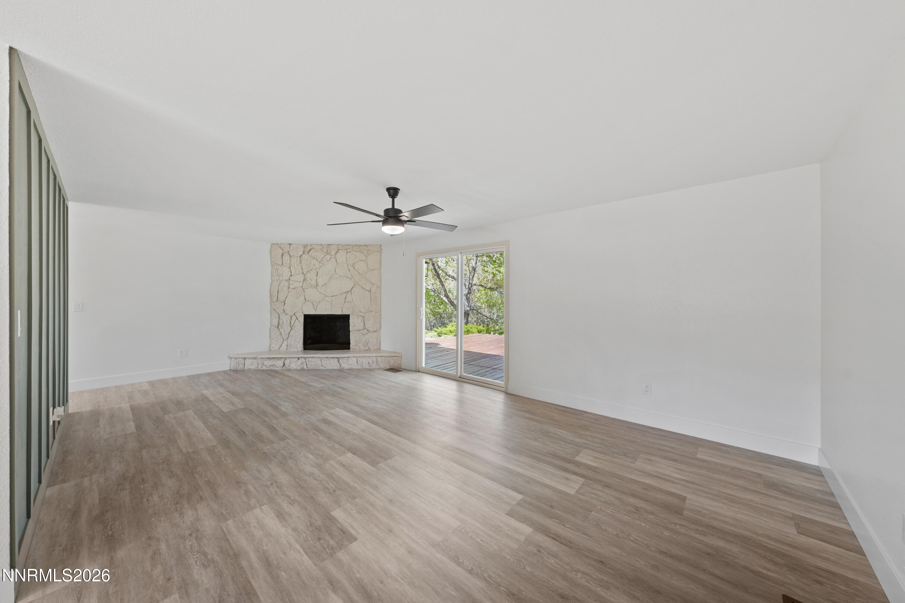 2240 Osceola Court Reno, NV 89506 - Photo 11 of 31 an empty room with wooden floor fireplace and windows