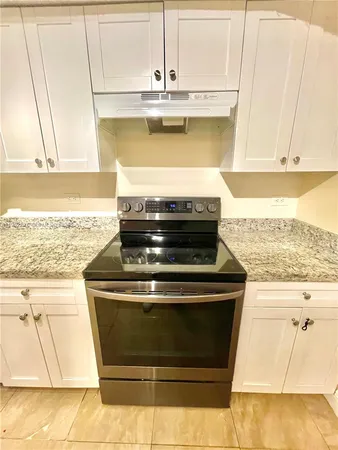 a stove top oven sitting inside of a kitchen
