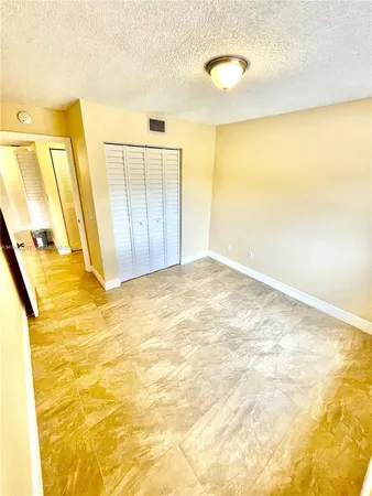 a view of a big room with wooden floor and brick wall