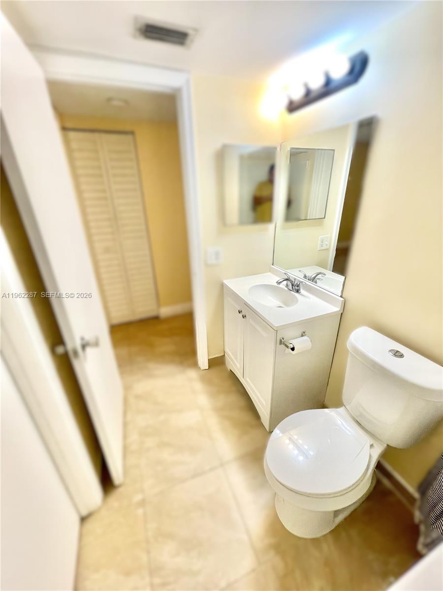3690 North 56th Avenue, Unit 921 Hollywood, FL 33021 - Photo 25 of 41 a bathroom with a sink a toilet a mirror and vanity