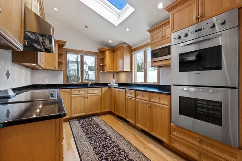 a kitchen with stainless steel appliances granite countertop a stove microwave and sink