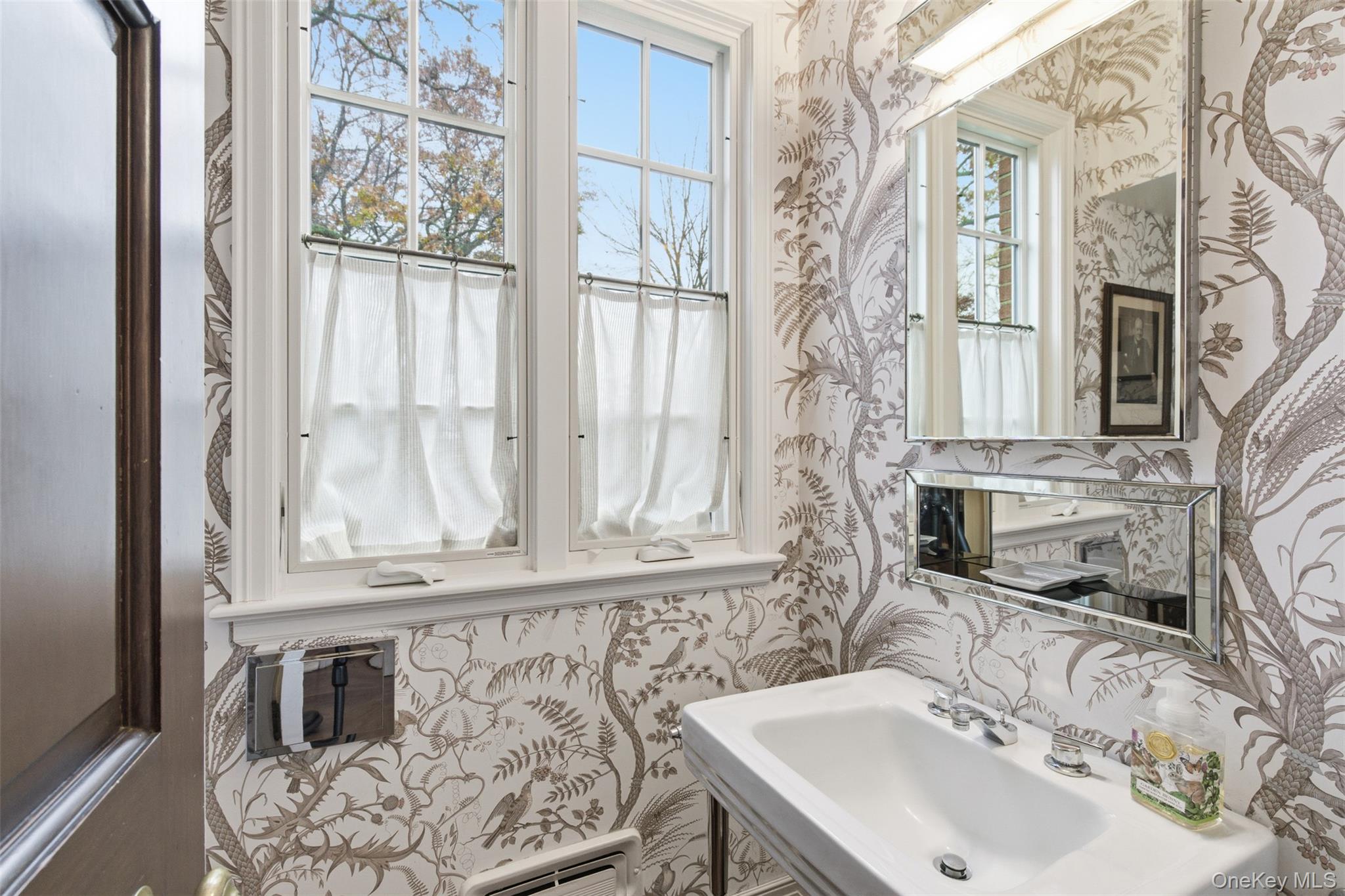 159 Factory Pond Road Mill Neck, NY 11560 - Photo 21 of 39 Half bathroom with wallpapered walls and a baseboard radiator.