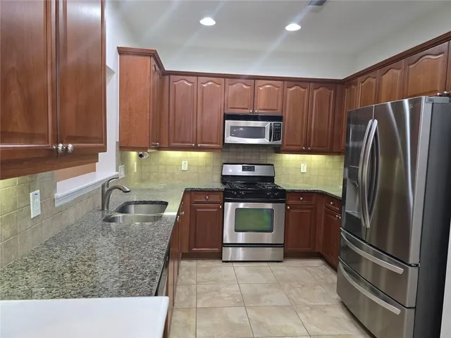 a bathroom with a toilet a sink a mirror and a window