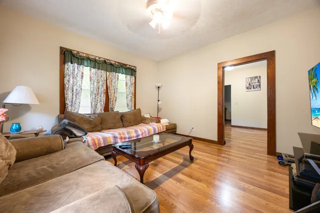 a living room with furniture and a wooden floor