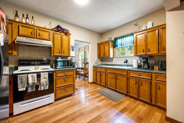 a kitchen with stainless steel appliances a stove microwave and sink