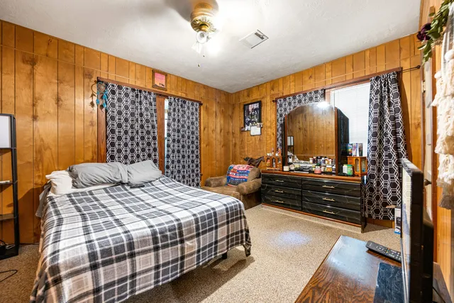 a bedroom with a bed and a large mirror on the dresser