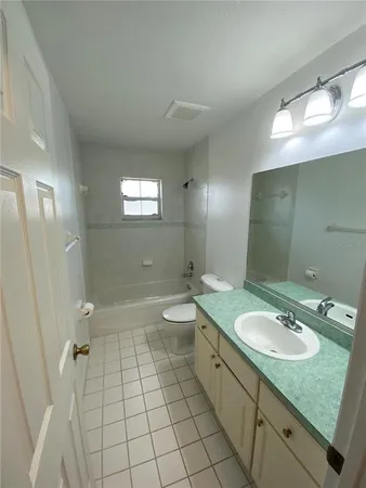 a bathroom with a granite countertop sink a toilet a mirror and shower