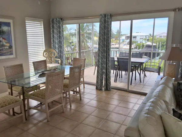 a dining room with furniture and large windows