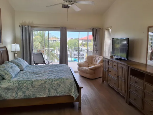 a bedroom with a bed and large windows