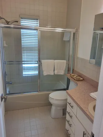 a bathroom with a granite countertop sink toilet and shower