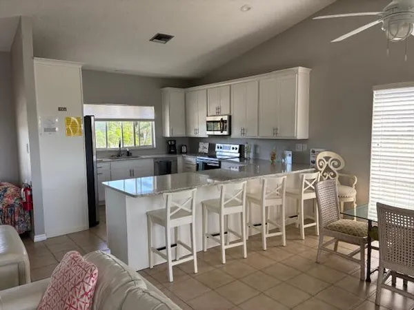 a kitchen with stainless steel appliances granite countertop a table and chairs in it