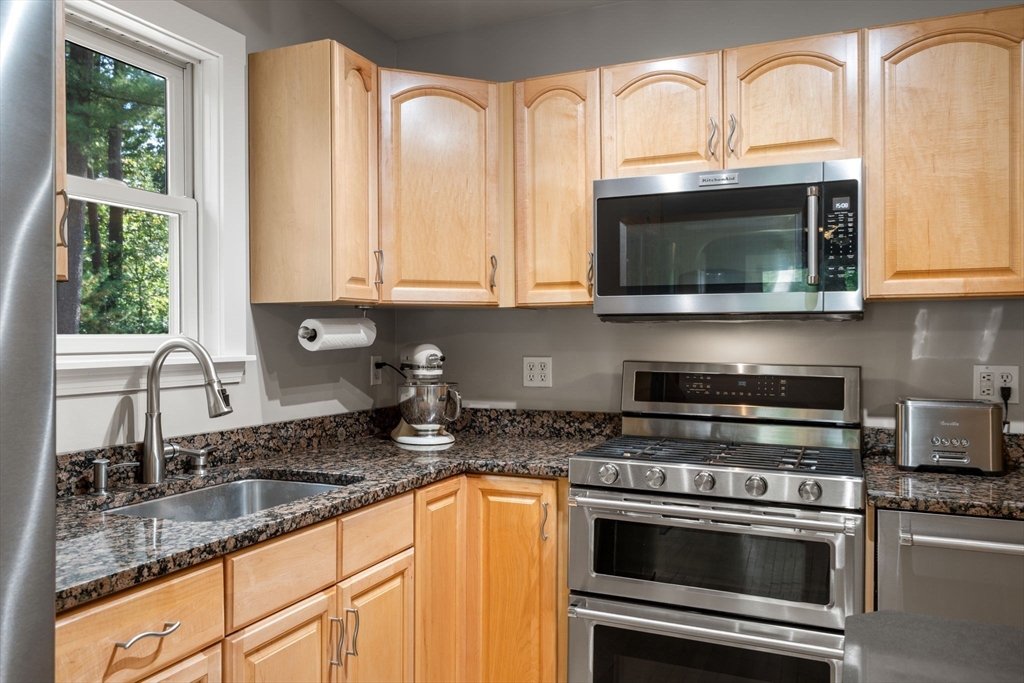 6 Grove Avenue Sharon, MA 02067 - Photo 4 of 27 a kitchen with granite countertop white cabinets stainless steel appliances and a sink