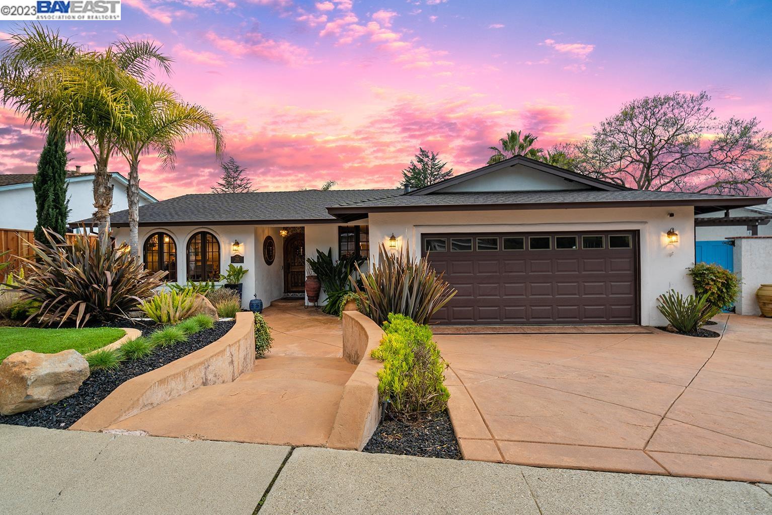 a front view of a house with a yard and potted plants