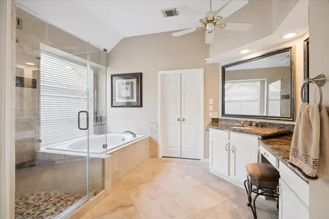 a spacious bedroom with a large bed and a chandelier