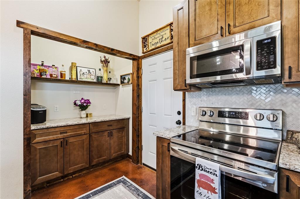 435 County Road 4875 Celeste, TX 75423 - Photo 13 of 35 a kitchen with stainless steel appliances a stove a microwave and wood cabinets