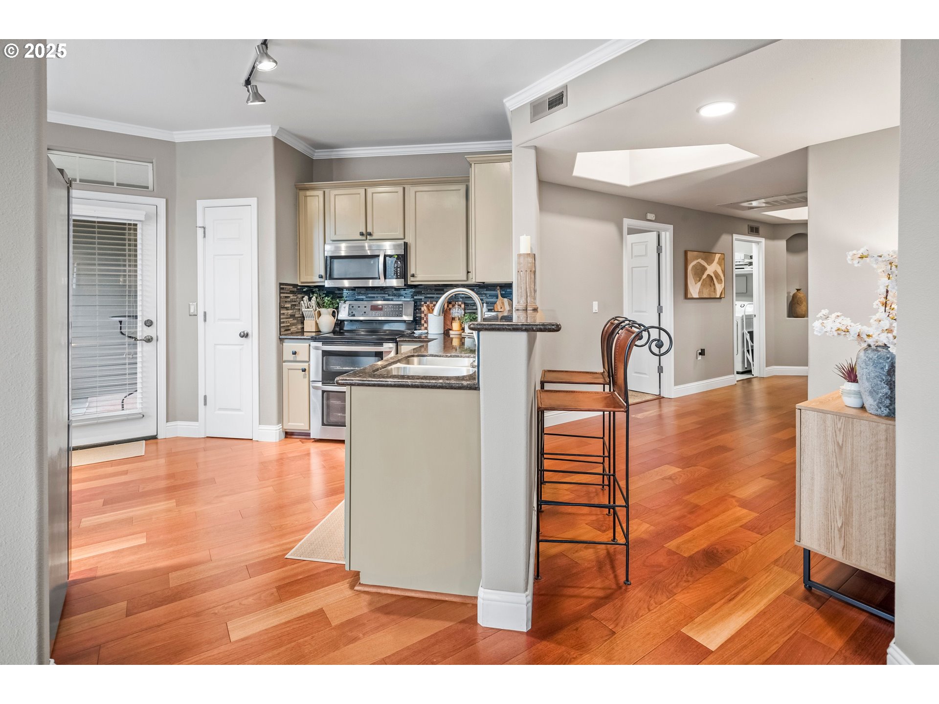 975 Springtree Lane West Linn, OR 97068 - Photo 16 of 48 a room with stainless steel appliances kitchen island granite countertop a stove a sink a refrigerator and white cabinets with wooden floor