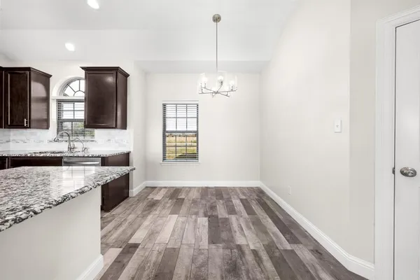 a bathroom with a granite countertop sink toilet a large mirror a bathtub and window