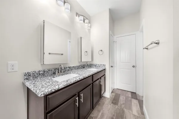 a bathroom with a granite countertop sink and a mirror