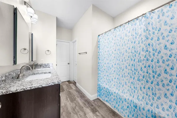 a bathroom with a granite countertop sink and a mirror