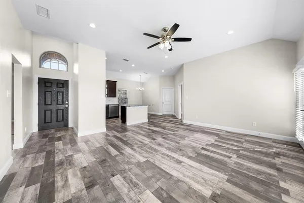 a view of a livingroom with a ceiling fan and wooden floor