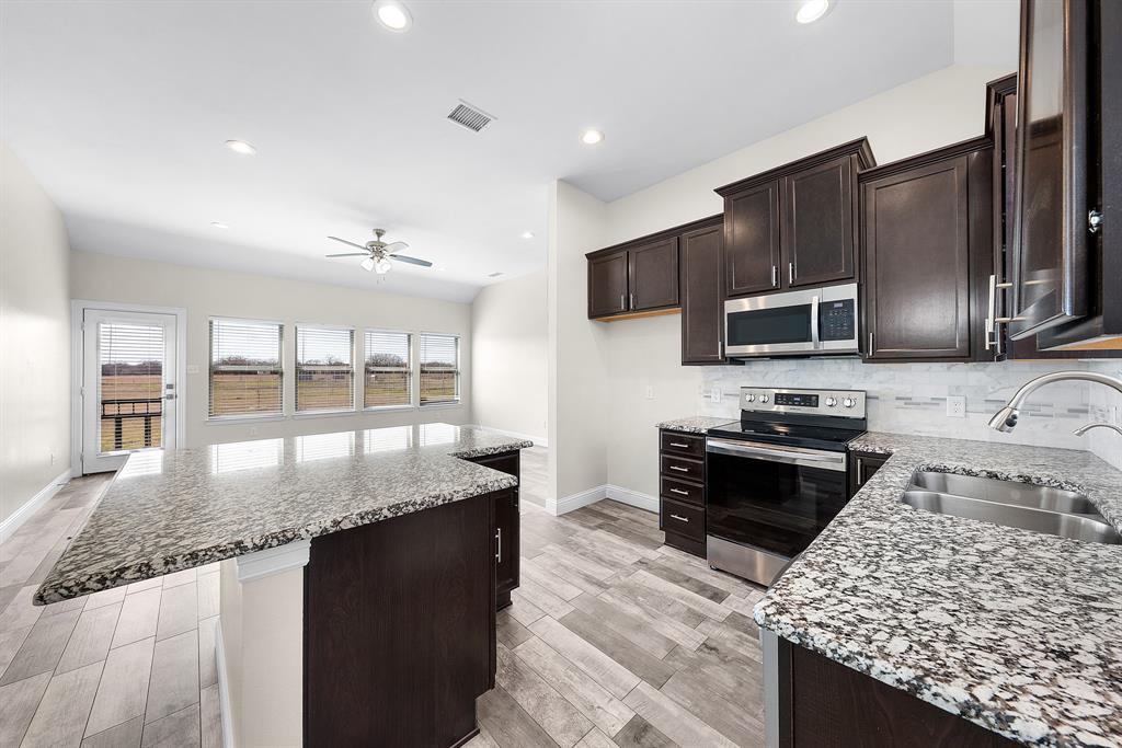 11729 County Road 313 Terrell, TX 75161 - Photo 9 of 25 a kitchen with stainless steel appliances granite countertop a sink stove microwave and refrigerator
