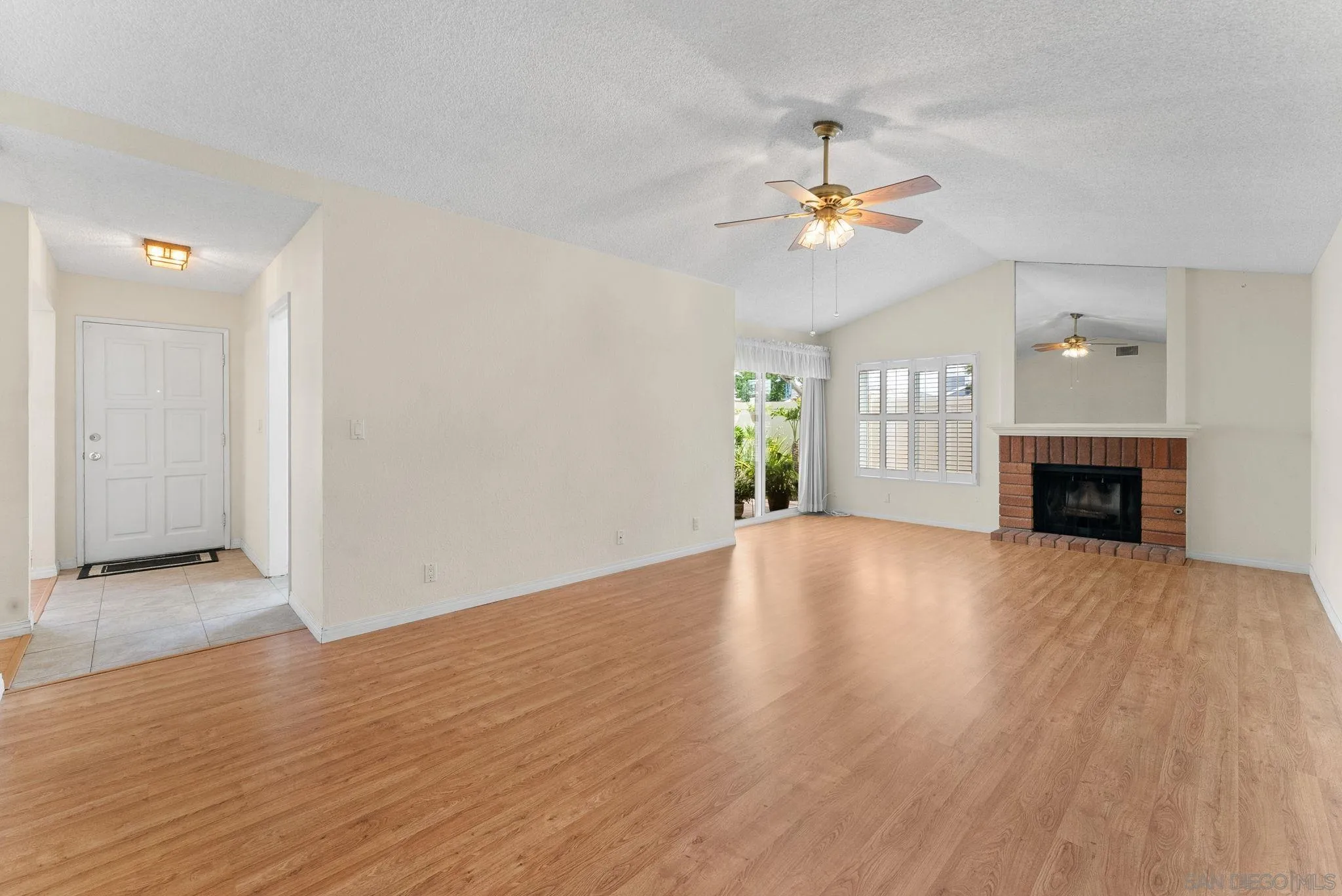10357 Bart Way Santee, CA 92071 - Photo 13 of 39 an empty room with wooden floor fireplace and fan