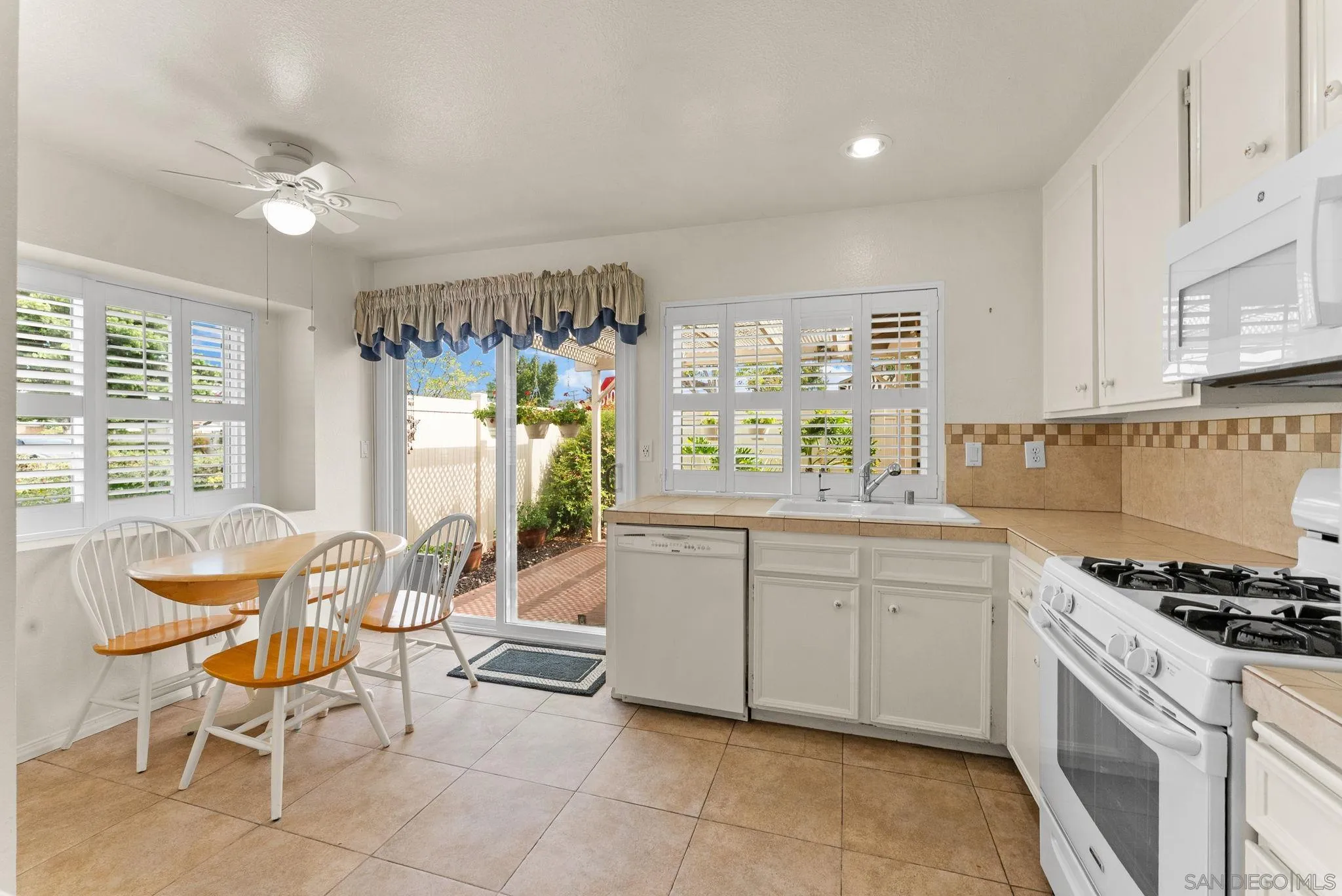 10357 Bart Way Santee, CA 92071 - Photo 4 of 39 a kitchen with a dining table chairs and white cabinets