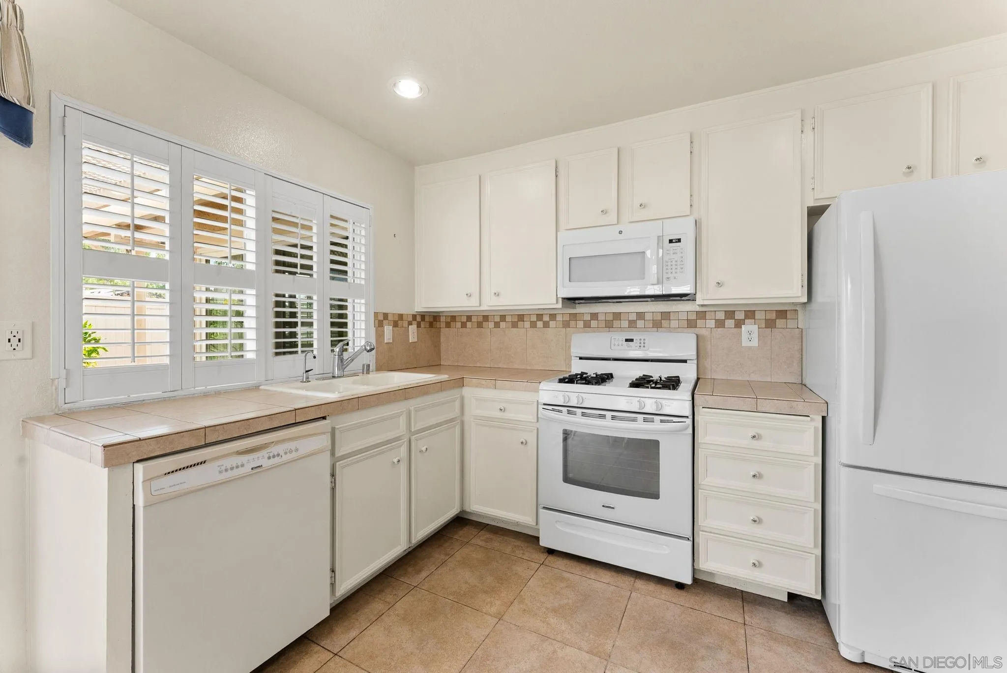 10357 Bart Way Santee, CA 92071 - Photo 5 of 39 a kitchen with white cabinets and white appliances